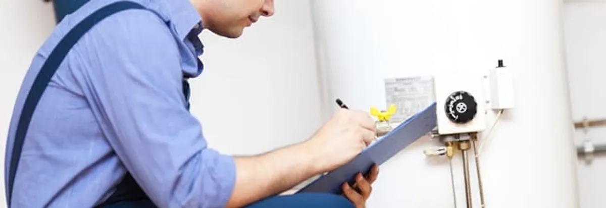 Water heater repair technician inspecting the unit and recording service notes in Boise, ID